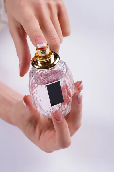 Close up of woman hands spraying perfume.
