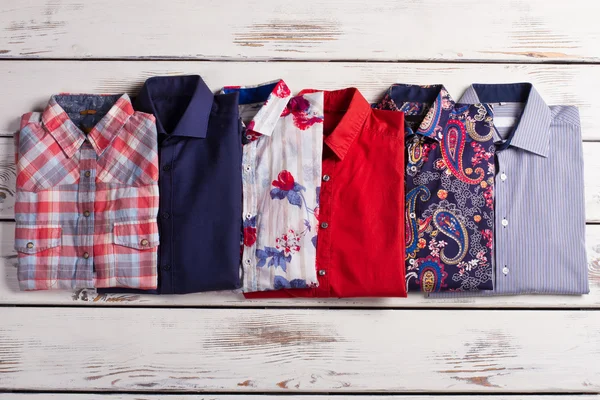 Many different bright stylish men's shirts with different colors
