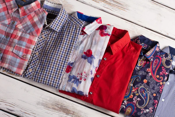 Multicolored men's shirts with different prints.