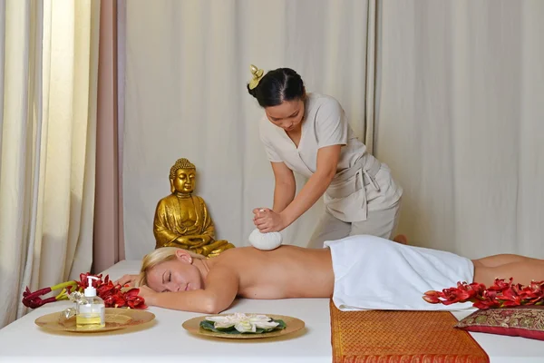 Young beautiful female receiving herbal ball massage