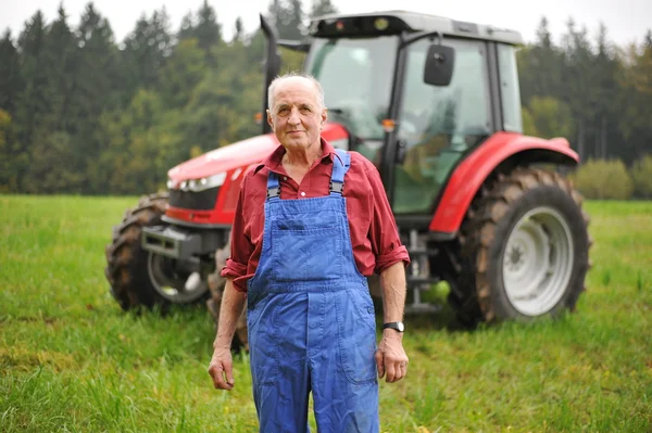 Farmer standing in front of his red tractor