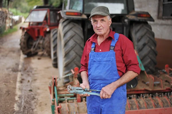 Farmer repairing his red tractor
