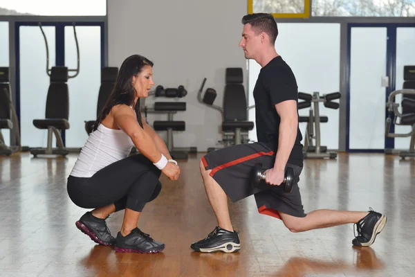 Man working out with female personal instructor