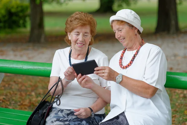 Two senior ladies reading news