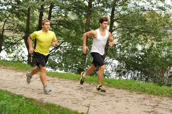 Two young athletes jogging / running in the park