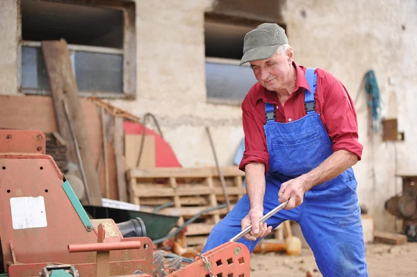 Farmer repairing his red tractor