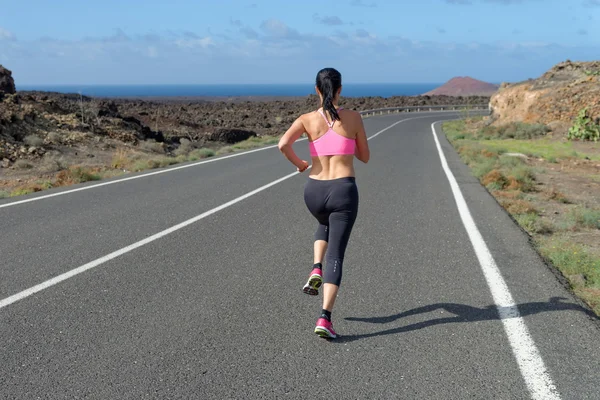 Runner woman running on mountain road in beautiful nature