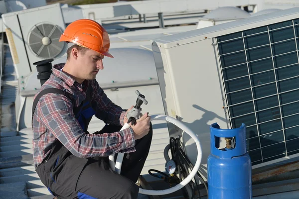 Young repairman fixing air conditioning system