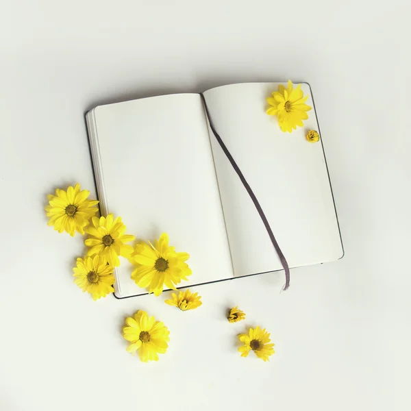 Toned mock up. Opened notepad and yellow gerbera flowers