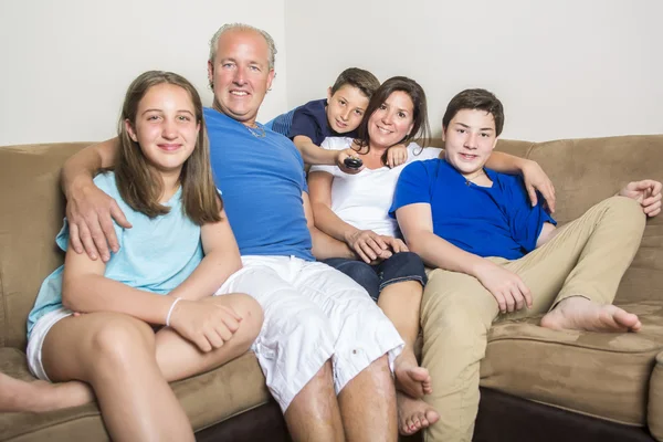 Family Relaxing Indoors Watching Television Together