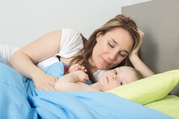 Happy family. baby and mother in blue bed