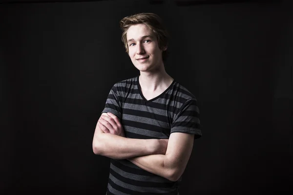 Young teenage boy being photographed in a studio.