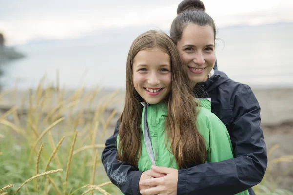 Family enjoying the rain and having fun outside on the beach  a gray rainy