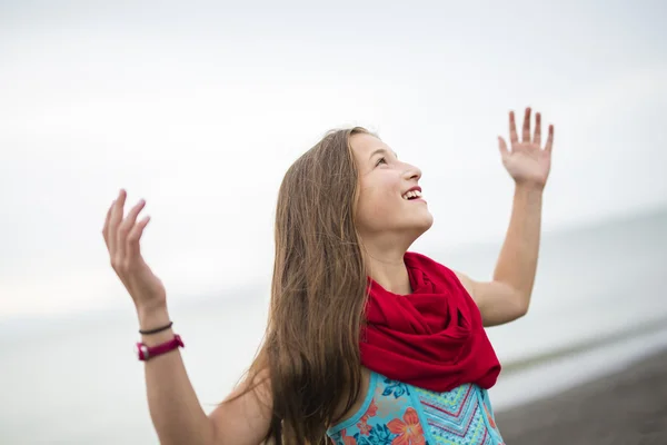 Girl enjoying the rain and having fun outside on the beach  a gray rainy