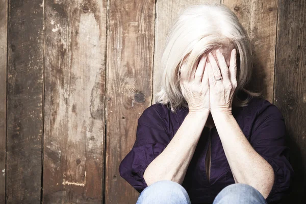 Depress senior person with wood background