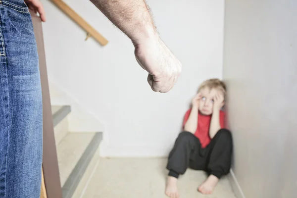 Boy sitting alone leaning on the wall