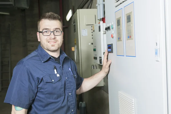 Repairman engineer control panel valve equipment in a boiler hou