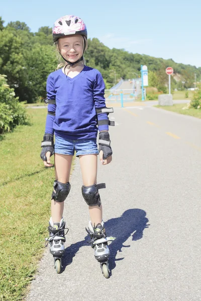 A Little girl in roller skates at a park
