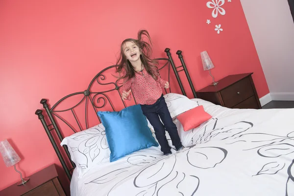 A Beautiful little girl jump on bed
