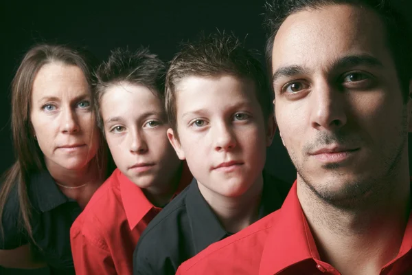 Family portrait of four siblings in front of black background