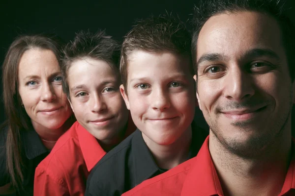 Family portrait of four siblings in front of black background