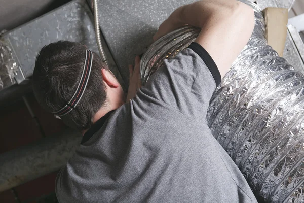 A ventilation cleaner man at work with tool