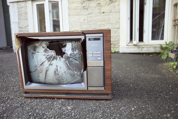 An old broken TV left on the street.