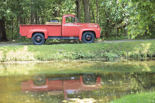 A old retro beautiful red truck  in a park