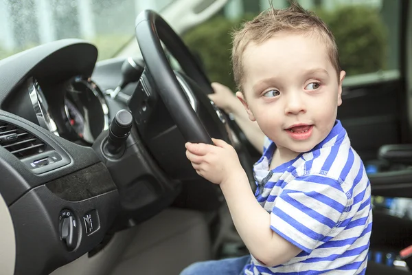 Cute little boy driving fathers car