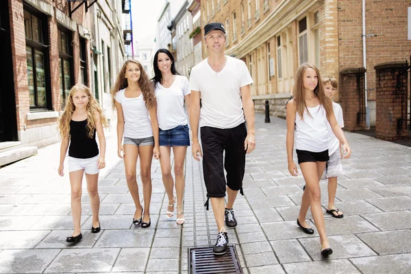 Summer family portrait of parents and kids outside in urban style