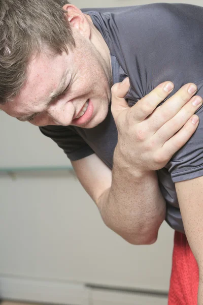 Portrait of a fitness man reaching for his knee in pain