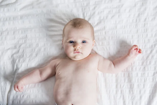 Cute four month old baby in bed at home