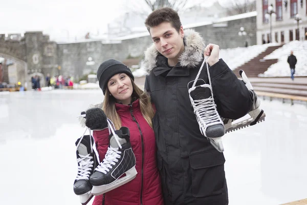 Ice skating couple having winter fun on ice skates Quebec, Canada.