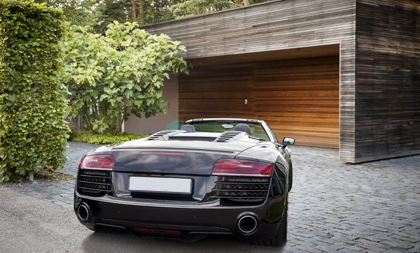Luxury sports car in front of a garage
