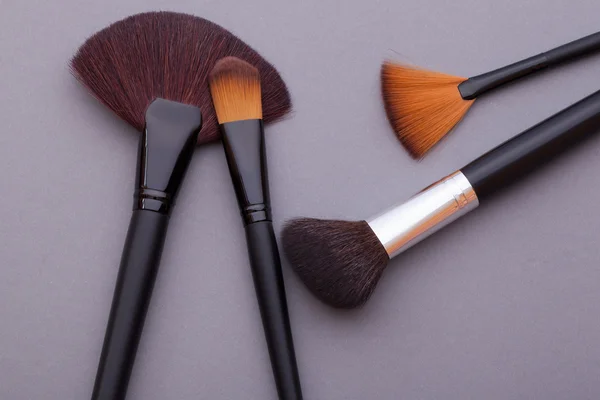 Many cosmetic brushes, overhead view.