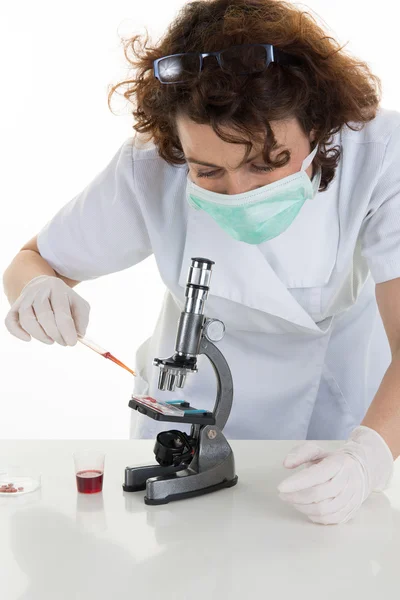 Female medical or scientific researcher or doctor wearing a surgical mask in a laboratory