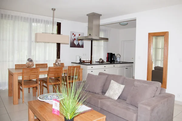 Warm interior of cosy living room with white sofas and tables.