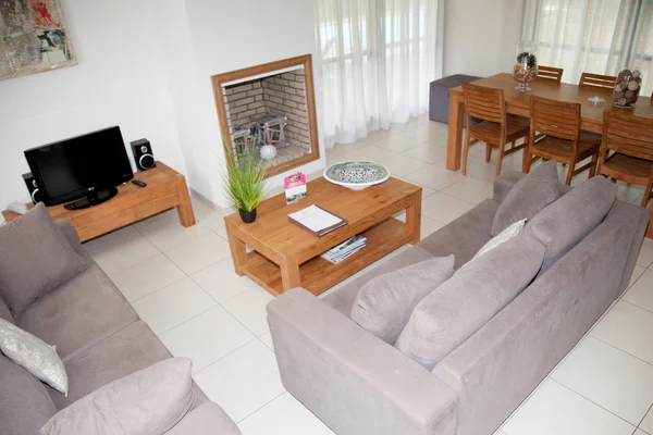 Warm interior of cosy living room with white sofas and tables.