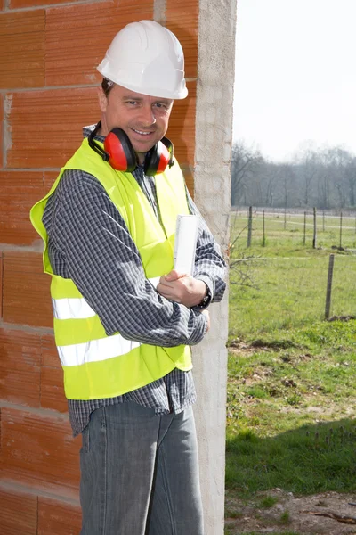 Man construction builder in white helmet and orange vest