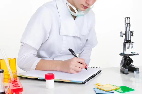 Female medical or scientific researcher writing in a clipboard