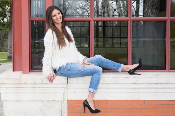 Handsome attractive girl wearing jeans high heels standing outside