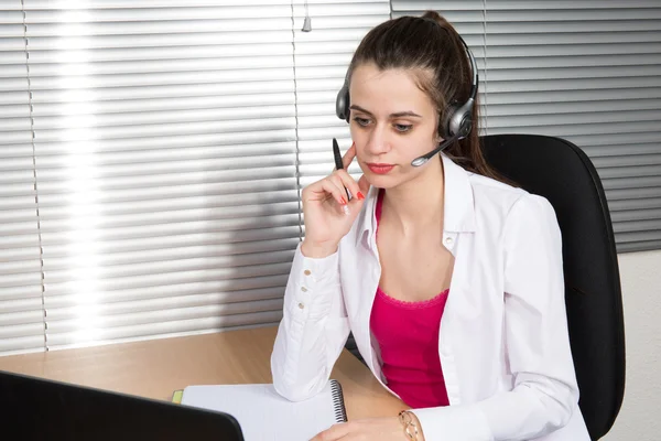 Young businesswoman or secretary working in her Office with a headset, she has a customer pitch