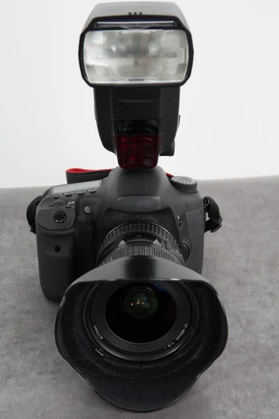 Professional camera with flash on grey background