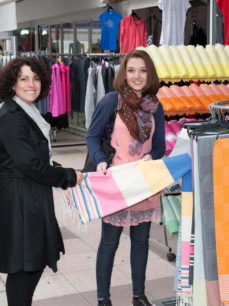 Two smiling women doing shopping in the city outside