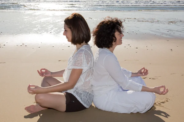 Yoga for two girls on summer in white clothes
