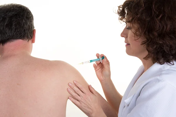 Serious doctor gives an injection on the back of a man