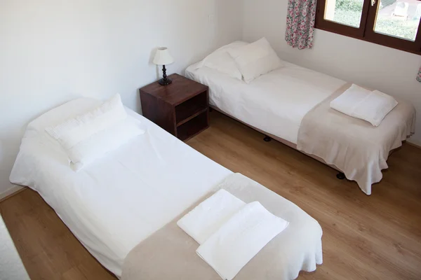 Two single beds in cozy bedroom in a bright house