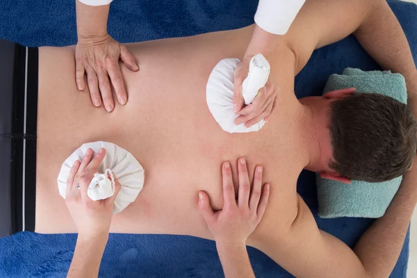 Young woman having body thai spa massage. Four hands massage.