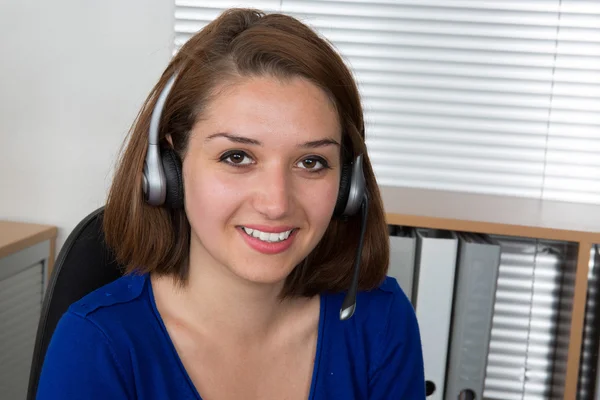 Pretty woman customer support operator with headset and smiling