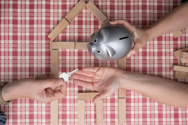 Money and key - safety and home expense concept an piggy bank